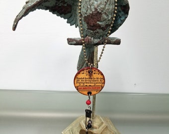 Heartsongs - Heavens Jubilee is an altered wood poker chip with metal findings and charms