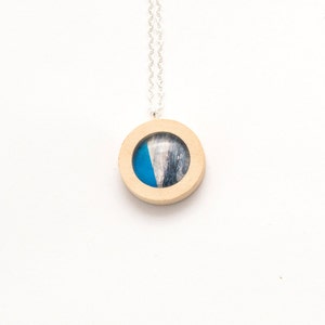 Wooden suspension . Round Pendant of wood and glass . The texture of wood and dark blue .
