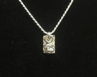 Handcrafted aquamarine gemstone on rectangle fine silver pendant.