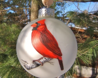 Northern Cardinals, one male, one female, on birch twigs. Handpainted on silver matte ball ornament.
