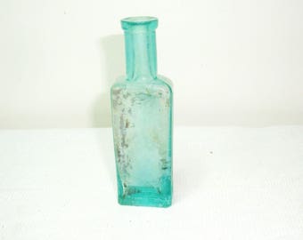 Old dug bottle. 4.25" tall, 1.25" wide, 5/8" thick. Cork bottle was washed in mild soapy water. Some residue remains. Circle mark bottom