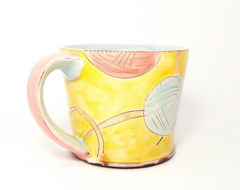 Yellow yarn knitting/crochet themed Earthenware mug. Wheel thrown, food safe mug made by Kaitlyn Brennan.