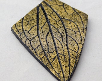Elegant black and gold pendant with leaf imprint
