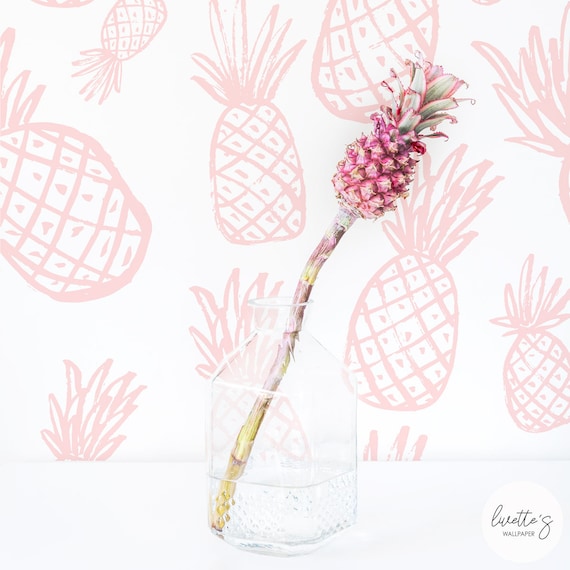 Peel and stick wallpaper features illustrations of pink pineapples. A glass vase holds a pineapple stem in water.