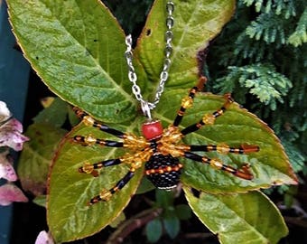 black and orange spider necklace made of beads.