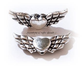 Antique silver-plated "pewter" (zinc-based alloy), 22x9mm double-sided angel wings with heart. Sold per pkg of 20