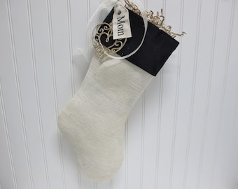 White burlap stocking with black velvet cuff embroidered tag and ornament included