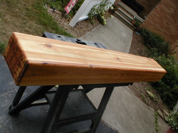 60 Cedar Custom Built Rustic Fireplace Mantel Custom built fireplace mantle has the look of a solid hand hewn beam with end grain ends but open in the back. Light weight compared to a solid beam and easier to mount. Mantle is 60 inches long