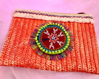 Clutch in orange with ethnic piece.