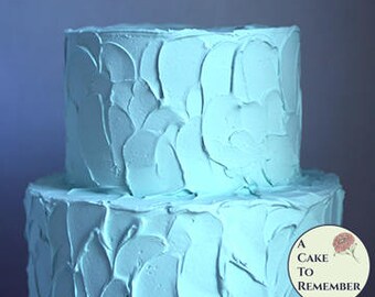 Two tiered pale teal fake cake with swirly rustic icing, 6" and 8" tiers. Faux wedding cake for dessert buffet decoration or party decor