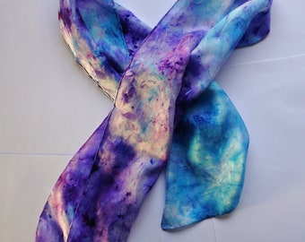 Hand painted pure silk scarf in vibrant blues and purples.