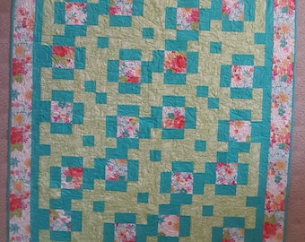 Cheerful lap quilt with hints of green, teal, fuchsia and pink.