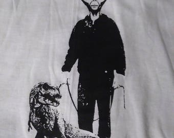 Alien walking trex screenprinted tshirt.