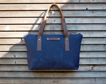 Waxed canvas tote bag with leather handles and zipper closure
