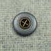 Grey metal cross button