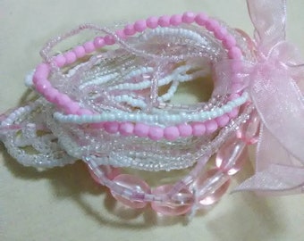 Vintage multiple pink and white beaded bracelet tied together with a pink ribbon.