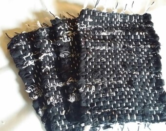 A black and white set of four handwoven mug rugs, coasters, hot pads