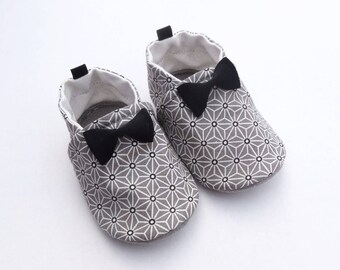 Sole leather baby shoes and cotton top with bows sewn on the top.