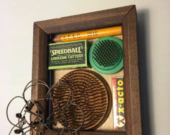 Folk art collage of found objects in frame