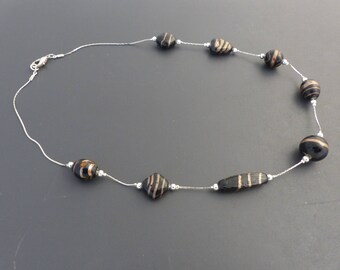 Black and gold necklace on snake chain