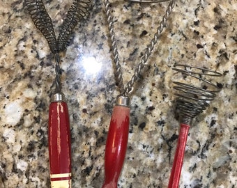 Vintage red handled lot of 3 kitchen utensils. Masher, whisk, small whisk.