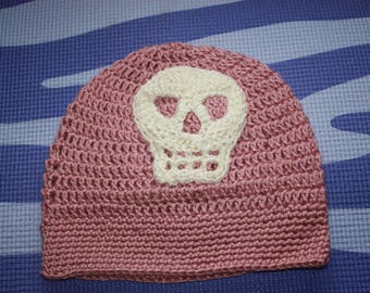 crocheted pink slouchy hat with white skull.