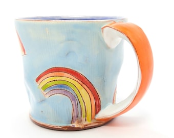 Puffy blue rainbow Earthenware mug. Wheel thrown, food safe mug made by Kaitlyn Brennan. This is a big handmade mug perfect for coffee