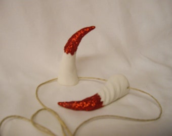 Small devil inspired horns in white with red glitter tips