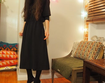 black mid length party dress with dolman sleeves and button detail