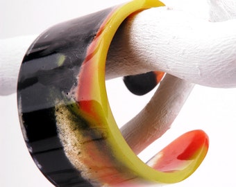 Bangle, resin cuff, black, orange and lemon marbled, fits S