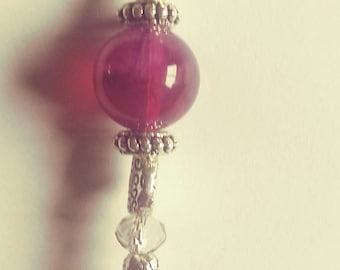 Purple zipper pull with a fairy charm