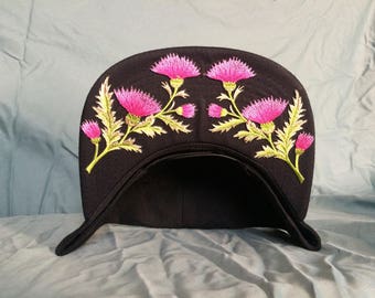 Black cap with pink thistle crown.