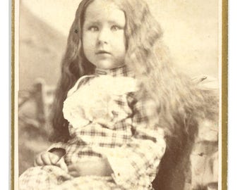 CDV of a little girl with long hair and a lazy eye / carte de visite