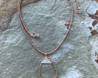 Boho style beaded chain with a copper oval pendant with silver accents