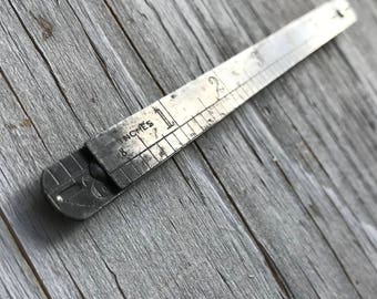 Vintage 2ft metal folding ruler in inches. Thin metal ruler, when opens neat mechanism 'locks' ruler straight.