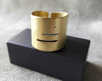 Brass man ring with stylized motif, open on the back.