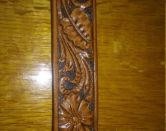 Hand tooled leather belt with floral design.