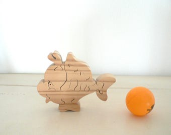 Animal puzzle "Gluttonous fish" in woodcut.
