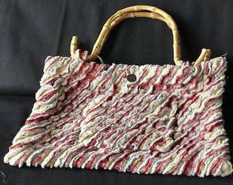 red, tan clutch purse with bamboo handles, outside pocket, multi layered fabric