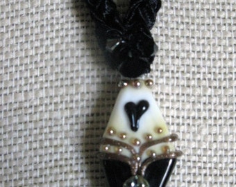 Exquisite necklace with black and cream lampwork focal bead and handknit ribbon yarn chain
