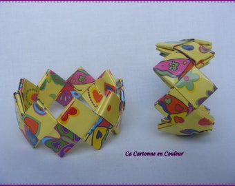 Bracelet closed multicolored recycled paper on a pale yellow background