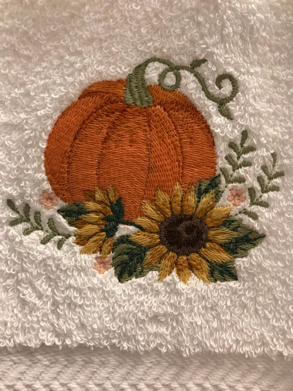 A Towel With A Pumpkin And Sunflower On It