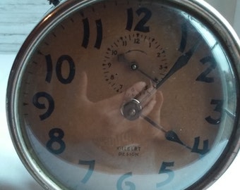 Vintage 1920s Gilbert Alarm Clock and working. Nice Stainless steel Housing. Clock Face Showing Age with Fading. Great Gilbert Name.