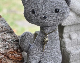 Cat Plush with bird skull pendant