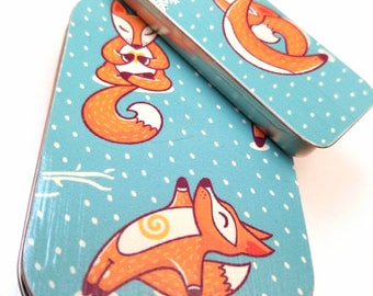 Large hinge tin and medium thin tin duo . . . Yoga foxes in the snow . . .