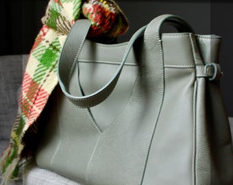 Worn leather shoulder bag in hand "Vertigo"