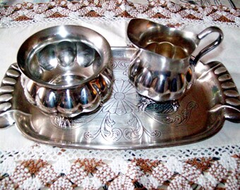 A silver plated milk jug, sugar bowl and tray