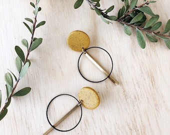 Clay and brass earrings with a large yellow ochre stud.