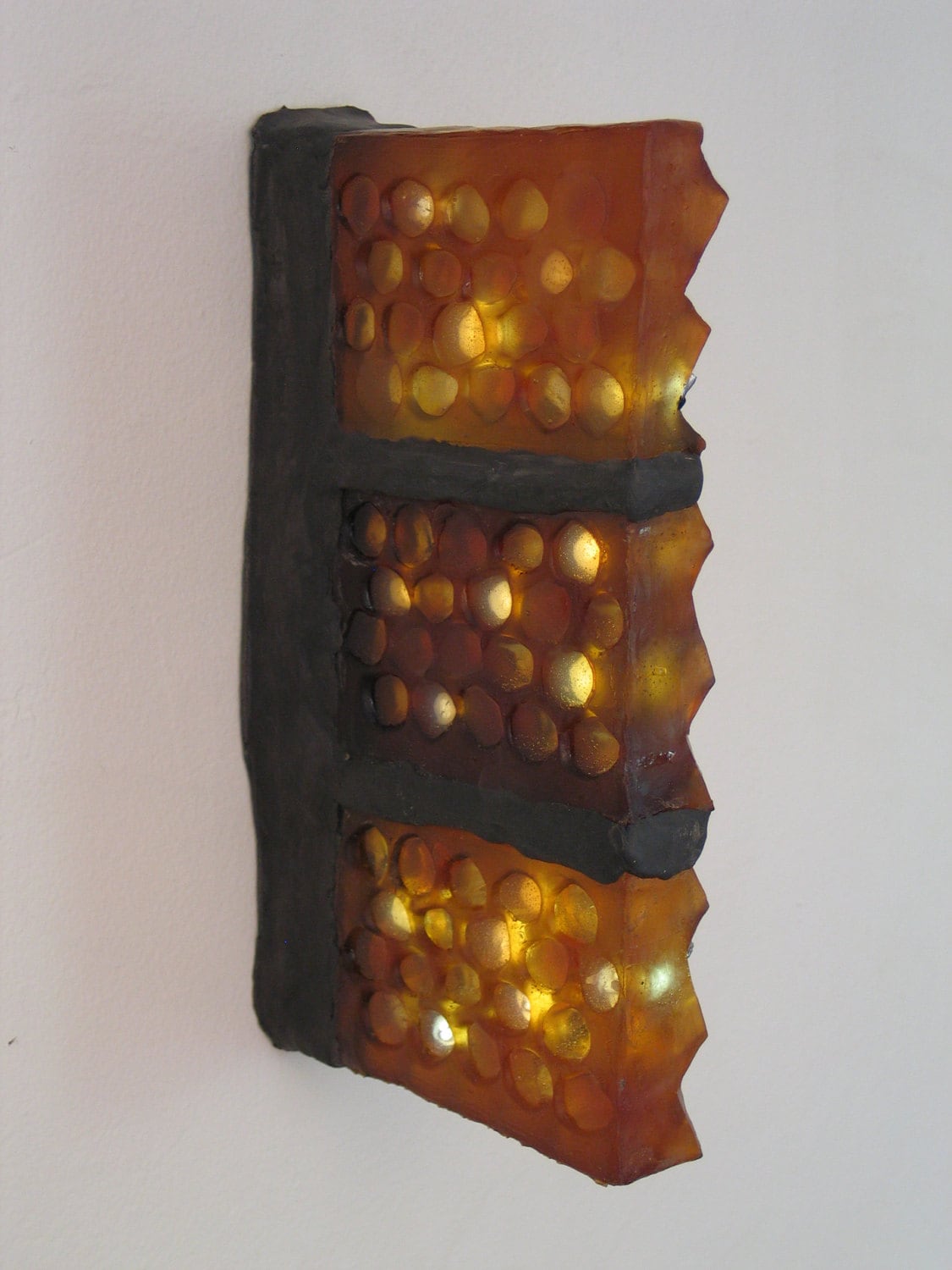 Translucent amber honeycomb with embedded LEDs .  Apis habilis:  Honeycomb Number 9