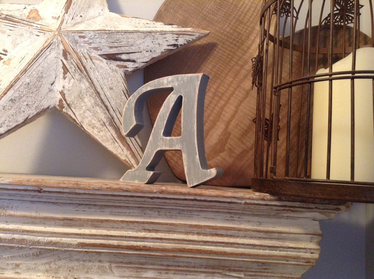 Letter A in Apple Chancery Font, painted white, with a grey over the top, and distressed